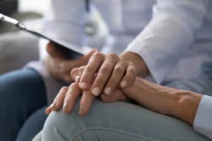 hospice register nurse case manager holding hands with patient